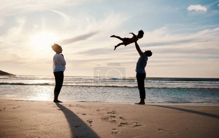Photo for Family, beach and child in air with parents, sunshine with happiness and together with bonding on vacation. Travel, adventure and mother, father and kid flying, happy people in nature with silhouette. - Royalty Free Image