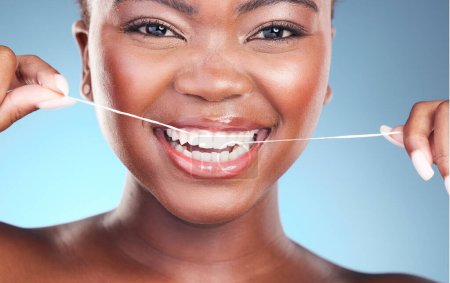 Photo for Happy woman, teeth and dental floss in cleaning, grooming or skincare against a blue studio background. Closeup of female person with big smile flossing in tooth whitening for oral, mouth or gum care. - Royalty Free Image
