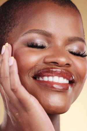 Photo for Beauty, makeup and a happy woman with hand on face for self care, skin glow and cosmetics. Closeup of african person or model with facial shine, eyelash extension and a smile on a studio background. - Royalty Free Image