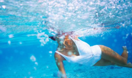 Foto de Perseguido y frenético - ConceptDanger. Inyección submarina de una hermosa joven nadando en el océano azul - Imagen libre de derechos