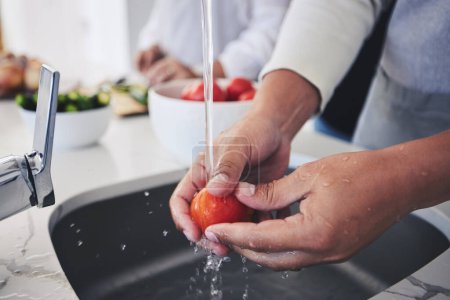Photo for Water, tomato and hands cleaning vegetable for cooking in a kitchen basin or sink in a home for hygiene as a chef. Salad, food and person prepare produce for a supper, lunch or dinner for diet meal. - Royalty Free Image