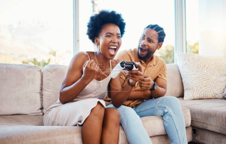Photo for Gaming, winner and a black couple on a sofa in the living room of their home together for bonding. Love, fun or competition with a gamer man and woman playing online using a console in their house. - Royalty Free Image