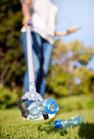 Photo for Park, pollution and closeup for cleaning, plastic bottle and and tools for climate change in nature. Person, garbage or trash on grass with help for environment, forest or earth with sustainability. - Royalty Free Image