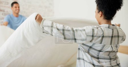Photo for Couple, making bed and cleaning in home with helping hand, support and partnership with smile. Woman, man and bedroom with sheet, blanket or duvet for housekeeping with teamwork for hygiene in house. - Royalty Free Image