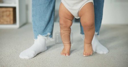 Photo for Legs, baby learning to walk with parents and growth, development and early childhood with motor skills. Family, support and first steps with trust, progress and balance with milestone and feet. - Royalty Free Image