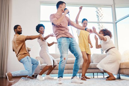 Photo for Karaoke, group and friends singing in the living room with a microphone to music, playlist or radio. Happy, diversity and young people dancing, bonding and having fun together with a song at home - Royalty Free Image