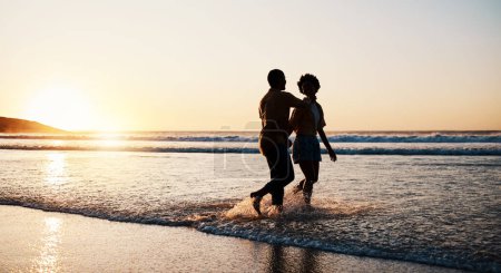 Photo for Beach sunset, sea water and silhouette couple walking, connect or enjoy romantic holiday in South Africa. Love, ocean waves and dark shadow of summer people bond, talking and relax on evening journey. - Royalty Free Image
