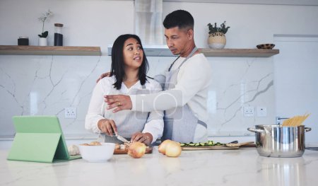 Photo for Tablet, cooking and couple in a kitchen, recipe and bonding with love, marriage and conversation. Home, man and woman with technology, online reading and nutrition with instructions and prepare lunch. - Royalty Free Image