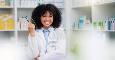 Photo for A friendly female pharmacist with a bright smile is about to help patients at the dispensary. Portrait of happy woman healthcare professional smiling at the pharmacy. A doctor taking off her glasses. - Royalty Free Image