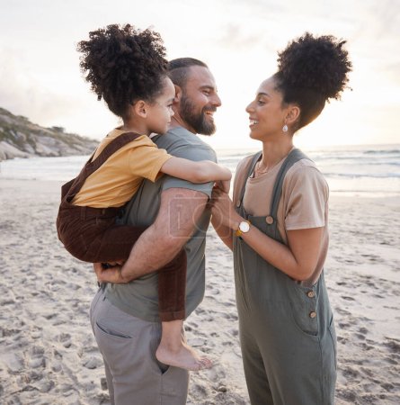 Photo for Piggyback, family and smile at beach at sunset, bonding and having fun together. Happy, mother and father of kid at ocean in interracial care on summer holiday, vacation trip or travel outdoor at sea. - Royalty Free Image