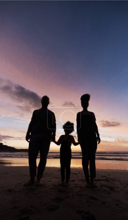 Photo for Silhouette, family at beach and holding hands at sunset, bonding or outdoor on mockup space. Shadow, sea and father, kid and mother at ocean in care, summer holiday or vacation to travel together. - Royalty Free Image