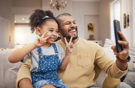 Foto de Selfie, feliz y un padre y un niño con un signo de paz en el sofá para las redes sociales o una videollamada. Sonríe, la familia y un padre tomando una foto con una niña y un gesto para transmitir en vivo en una casa. - Imagen libre de derechos