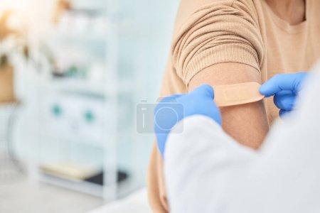 Photo for Bandaid, vaccine and arm of patient with doctor for healthcare, medical consultation and bandage for covid injection. Hands, hospital nurse and plaster for an injury, virus or safety while sick. - Royalty Free Image