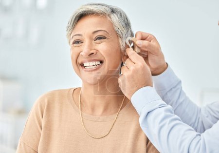 Photo for Senior patient, hearing aid and doctor hands, ear and listening, help and trust, healthcare and medicine. Medical tech, consultation with ENT specialist and health, happy woman and people at clinic. - Royalty Free Image