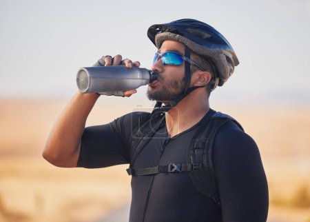 Photo for Fitness, health and man cyclist drinking water at race, marathon or competition training. Sports, workout and thirsty male athlete with hydration for wellness at an outdoor cardio exercise in nature - Royalty Free Image