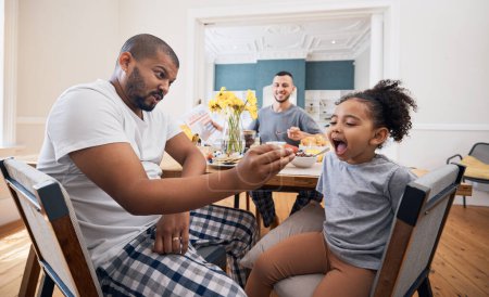 Photo for Gay couple, breakfast and father feeding child meal, food or morning cereal for youth development in home dining room. Family bond, adoption or homosexual dad smile for hungry kid girl eating. - Royalty Free Image