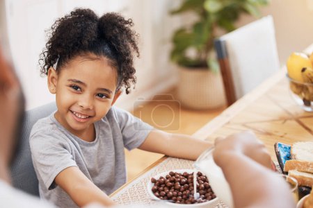 Photo for Kitchen, breakfast cereal and happy family child smile for morning food, meal and parent pour milk. Home, happiness and young kid, youth girl and ready for nutrition, hungry and eating in Brazil. - Royalty Free Image