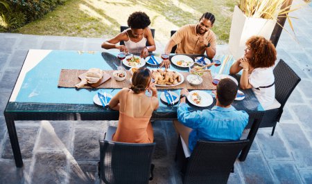Photo for Food, top and friends in house backyard to relax on holiday celebration or vacation in summer together. Party, home or happy people eating to bond at table in conversation for lunch or brunch meal. - Royalty Free Image