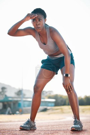 Photo for Sweating, tired and black woman at stadium for a race, training or breathing after cardio. Sports, workout and an athlete or African runner with a break after fitness, running or exercise on a track. - Royalty Free Image