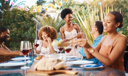 Photo for Group of friends at lunch, party in garden with smile, eating and happy event with diversity. Outdoor dinner, men and women at table with food, wine and talking together in backyard with celebration - Royalty Free Image