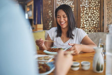 Photo for Happy, lunch and a woman at a restaurant for Chinese food or bonding at a table. Smile, hungry and a girl or people at a cafe for fine dining, Asian cuisine or eating dinner or a meal together. - Royalty Free Image