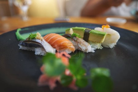 Téléchargez les photos : Japonais, sushis et plats de luxe dans un restaurant pour le dîner ou le déjeuner dans un café asiatique sain sur la table. Assiette, cuisine et plats gastronomiques à emporter ou fruits de mer à partir d'un menu de saumon pour l'alimentation ou la nutrition. - en image libre de droit