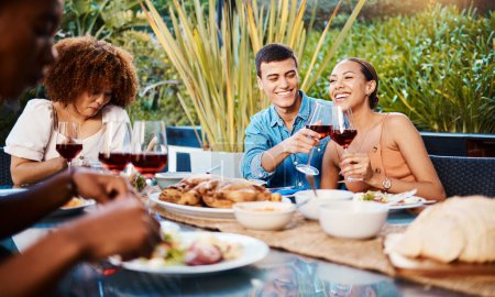 Photo for Happy, friends and cheers with wine glass at restaurant, bonding and having fun. Smile, alcohol and group of people toast at dinner party, celebration and drink, eating food and together at table. - Royalty Free Image
