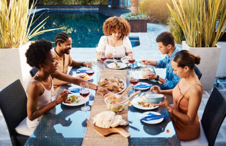 Téléchargez les photos : Groupe d'amis au déjeuner, fête dans le jardin et heureux événement avec la diversité, la nourriture et le vin pour coller ensemble. Dîner en plein air, hommes et femmes à table, personnes qui mangent avec des boissons dans la cour en été - en image libre de droit