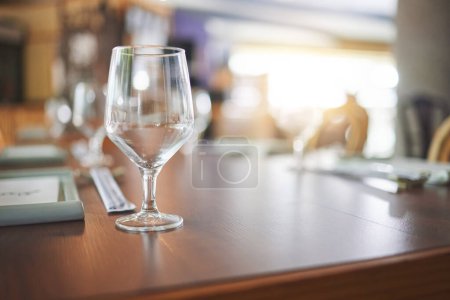 Foto de Bokeh, almuerzo y copa en una mesa en un restaurante de agua, alcohol o vino. Cena, cristal y vajilla para tomar una copa en una cafetería o cafetería durante la cena para disfrutar de una experiencia gastronómica de lujo. - Imagen libre de derechos