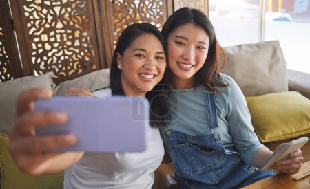 Photo for Selfie, love and a lesbian couple in a restaurant for a romantic date together on their anniversary. LGBT, smile and happy asian woman with her partner in a cafe for celebration of a milestone event. - Royalty Free Image