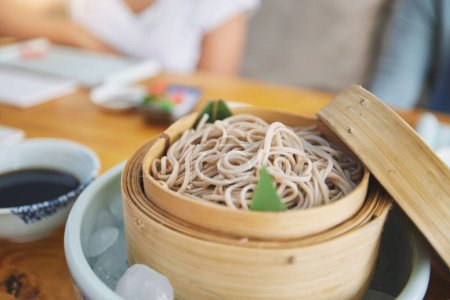 Téléchargez les photos : Restaurant, bambou et gros plan d'un bol de nouilles pour une cuisine asiatique authentique pour l'alimentation. Nourriture, marmite à vapeur et zoom des ramen japonais pour un repas nutritionnel pour le dîner, le déjeuner ou le souper dans un restaurant - en image libre de droit