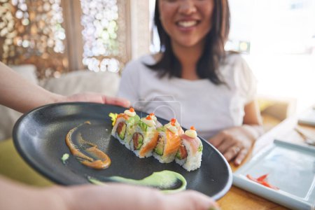 Téléchargez les photos : Assiette de sushi, restaurant et mains de personne, serveur ou serveur avec choix de nourriture, commande ou déjeuner pour le service de dîner. Hôtellerie, cuisine japonaise et cafétéria avec repas pour le client. - en image libre de droit
