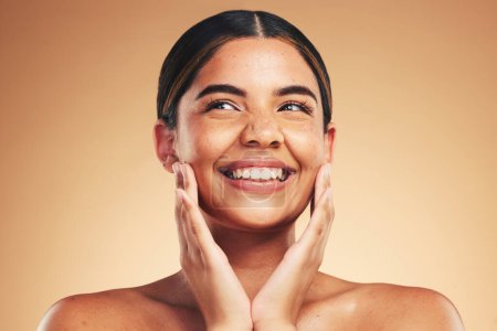 Skincare, happy and hands on natural woman face in studio for cosmetic, wellness or dermatology on brown background. Beauty, smile and model excited for glowing skin, results or self love cosmetology.