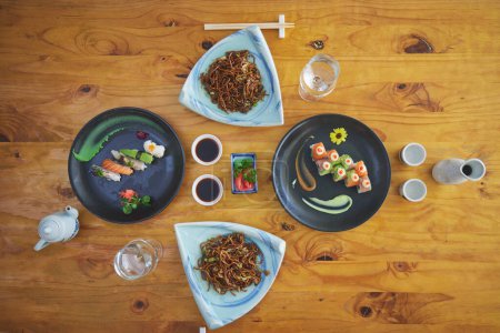 Téléchargez les photos : Restaurant Sushi, traiteur et assiette en vue supérieure pour le service, le déjeuner ou le dîner avec sauce soja, baguettes ou poisson. Cuisine japonaise, plateau et nourriture dans le café, luxe et manger pour la nutrition dans l'alimentation. - en image libre de droit