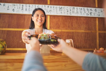 Foto de Sushi, trabajadora de restaurante y mujer con sonrisa de comida y comida asiática en una cocina. Happy, camarera o chef trabajando con salmón rollo almuerzo orden con la cocina en el bar japonés con servicio. - Imagen libre de derechos