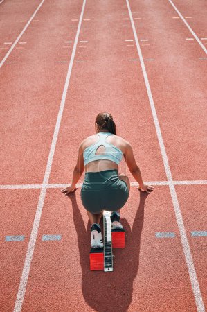 Photo for Start, running and fast with woman on race track for sports, competition and marathon. Exercise, health and wellness with runner training in stadium for challenge, speed and energy performance. - Royalty Free Image