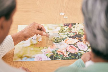 Photo for Puzzle on table, entertainment and senior couple in home for bonding, fun activity and relax together. Retirement, marriage and above of man and woman with jigsaw for playing games, hobby and connect. - Royalty Free Image