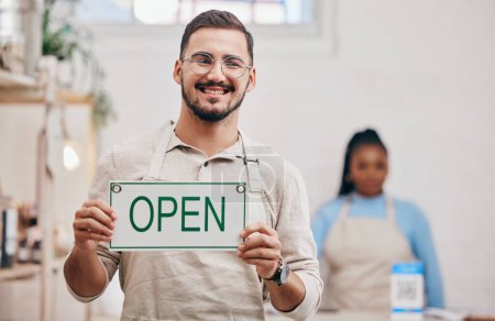 Photo for Open, sign and man with small business or restaurant happy for service in a coffee shop, cafe or store with a board. Smile, manager and portrait of an entrepreneur ready for operations with billboard. - Royalty Free Image