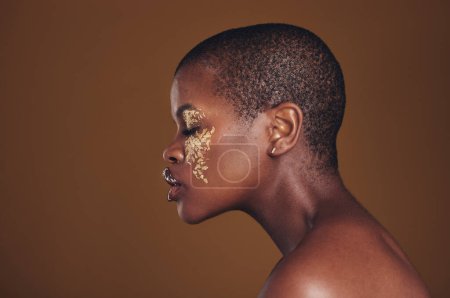 Foto de Arte, perfil de mujer negra con maquillaje dorado y fondo borroso, pintura brillante y cosméticos. Brillo, brillo y modelo africana en estudio para la belleza, la moda y la libertad estética en el cuidado de la piel de lujo - Imagen libre de derechos