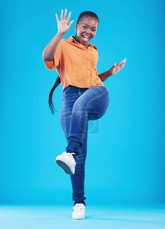 Photo for Woman, excited and leg up to celebrate in studio for achievement, promotion or sale deal. Portrait of African person on a blue background for happiness, winning and good news or fashion announcement. - Royalty Free Image