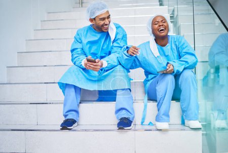 Photo for Surgeon, conversation and laughing on hospital stairs with phone and funny meme. Healthcare, medical and doctor team relax with comic and conversation together with mobile and social networking. - Royalty Free Image