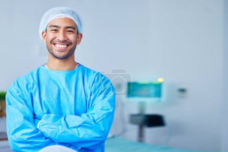 Photo for Portrait, surgeon and Asian man with arms crossed in hospital, healthcare and wellness. Face, happy doctor and medical professional, expert nurse and confident surgery employee in scrubs in Cambodia. - Royalty Free Image
