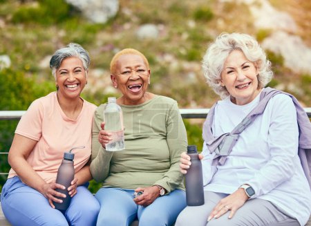 Foto de Mujeres mayores, fitness o retrato de amigos en actividades al aire libre juntos para la salud o el ejercicio durante la jubilación. Apoyo, diversidad o personas mayores felices bebiendo agua para relajarse en el descanso en el entrenamiento. - Imagen libre de derechos