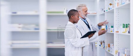 Photo for Discussion, tablet and pharmacists checking medication for inventory, stock or medical research. Healthcare, medicine and senior chemist mentor teaching female pharmaceutical student with technology - Royalty Free Image
