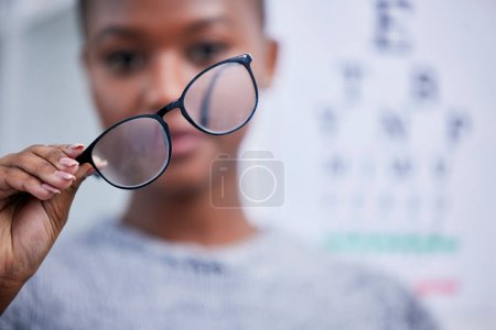 Foto de Optometría, vista y mujer negra con gafas para visión, cuidado ocular y salud óptica en clínica. Cuidado de la salud, optometrista y persona con lentes, monturas y gafas graduadas para probar los ojos. - Imagen libre de derechos
