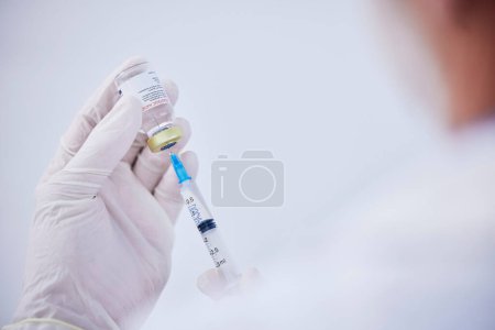 Photo for Vaccine bottle, needle and hands of doctor for safety, healthcare and pharmaceutical medicine. Closeup, virus injection and nurse prepare vaccination with vial, medical drugs and immunity in clinic. - Royalty Free Image