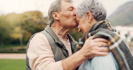 Photo for Forehead, kiss and senior couple in a park with love, happy and conversation with romantic bonding. Kissing, old people and elderly man embrace woman with care, romance or soulmate connection outdoor. - Royalty Free Image