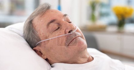 Photo for Oxygen, hospital bed and senior man sleeping with ventilation and breathing tube support in a clinic. Elderly patient, medical care and emergency room with male person at a doctor for healthcare. - Royalty Free Image