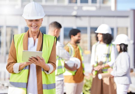 Photo for Tablet, architecture and a senior woman construction worker on a building site with her team in the city. Technology, planning and safety with a female engineer reading a blueprint on the internet. - Royalty Free Image