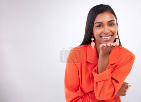 Photo for Smile, portrait and Indian woman blowing kiss in studio for flirting, care or romance gesture on grey background. Happy, face and female model with hand kissing emoji for thank you, gratitude or love. - Royalty Free Image